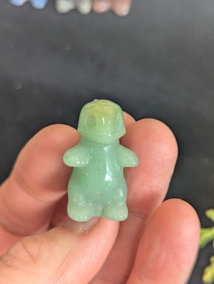 Front view of a 3cm Charmeleon carved from translucent Green Aventurine.