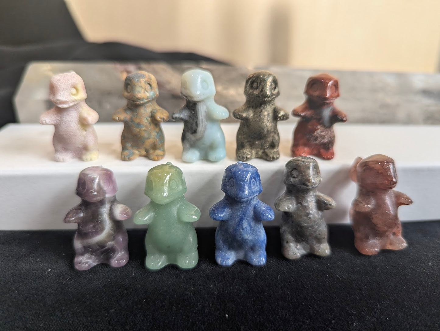 A group of hand-carved Charmeleon Pokémon totems in assorted natural minerals.