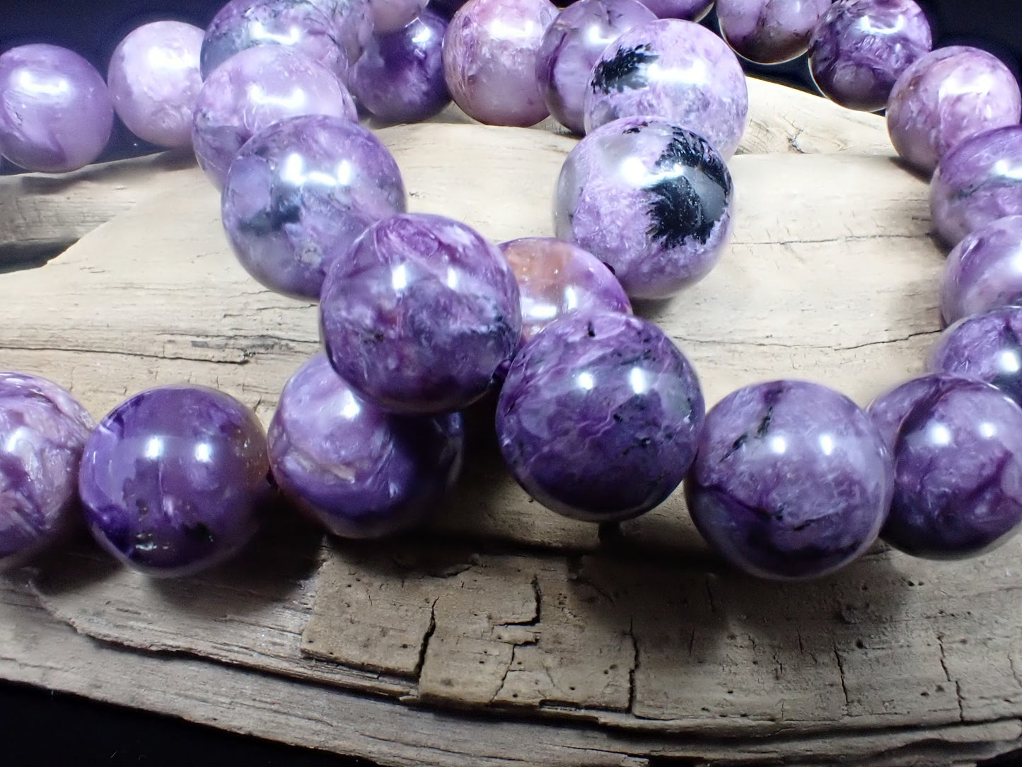 Macro detail of natural Charoite bead texture showing fibrous chatoyancy.