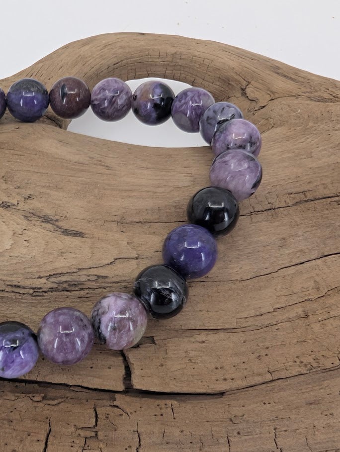Close-up of polished charoite beads showing purple veining