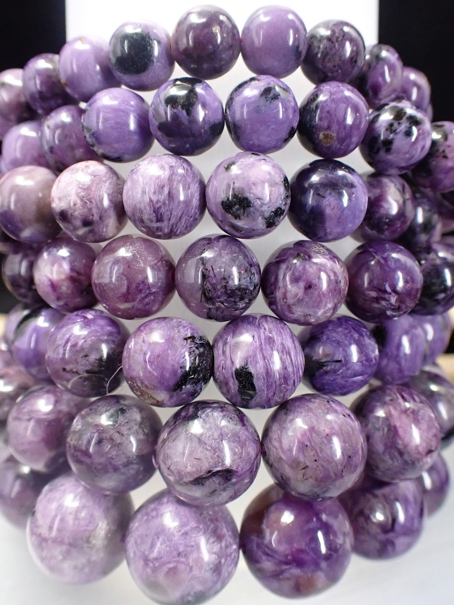 Close up of AAA Charoite beads showing distinct violet swirls and black Aegirine accents.