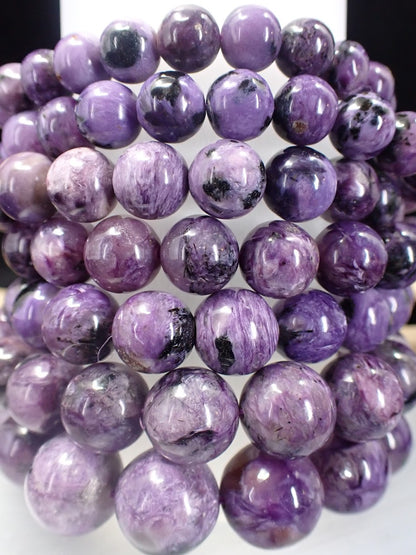 Close up of AAA Charoite beads showing distinct violet swirls and black Aegirine accents.