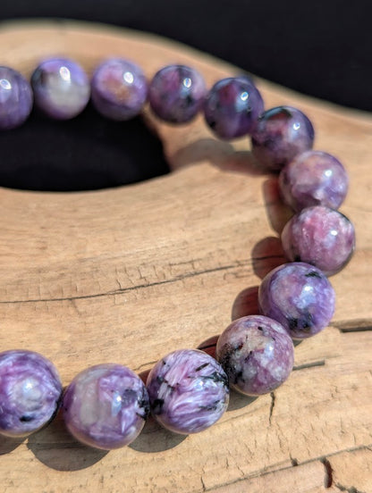Macro detail of a 10mm AAA Charoite beaded bracelet displaying vibrant violet colouration and distinct fibrous crystal structure.