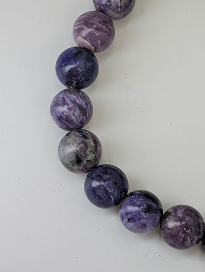 Detailed macro of charoite beads showing fibrous chatoyance