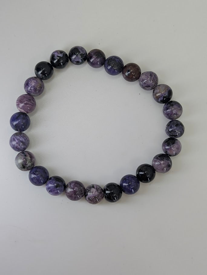 Full view of 8mm charoite gemstone bracelet on white background