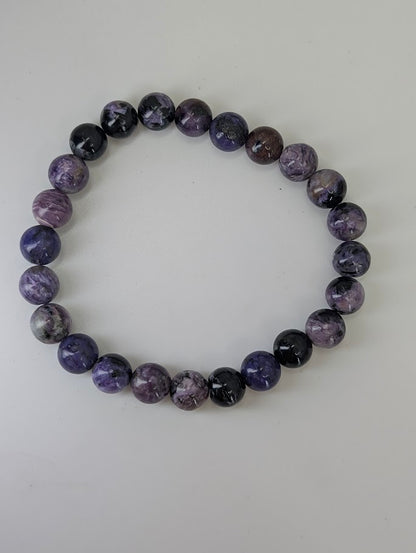 Full view of 8mm charoite gemstone bracelet on white background
