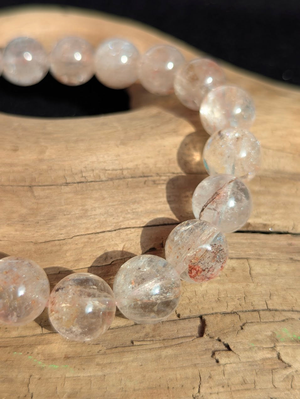 Macro detail of 11mm Cherry Blossom Garden Quartz beads capturing the faint hematite inclusions suspended in a highly transparent matrix.