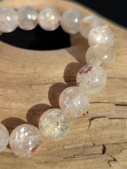 Macro close-up of 12mm Cherry Blossom Garden Quartz round beads highlighting the flawless lapidary polish and internal ethereal pink formations.