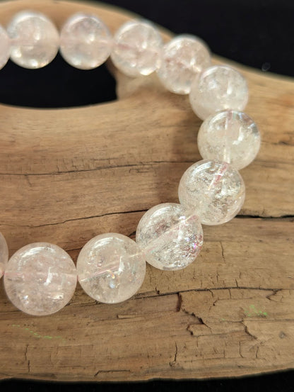 Macro photograph of 13mm Cherry Blossom Garden Quartz beads highlighting the water-clear host material and vivid internal peach colours.