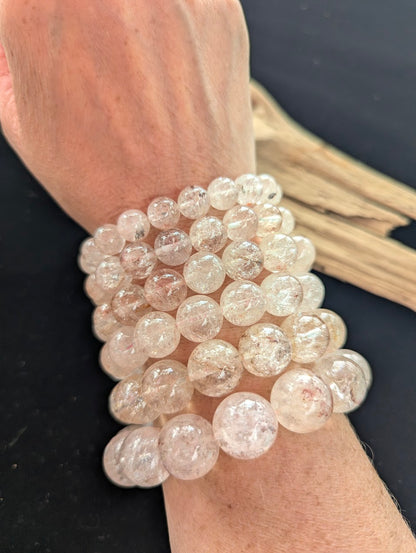 Stack of intuitively selected AAA Grade Brazilian Cherry Blossom Garden Quartz beaded bracelets worn together on a wrist, demonstrating water-clear clarity and delicate pale pink inclusions.