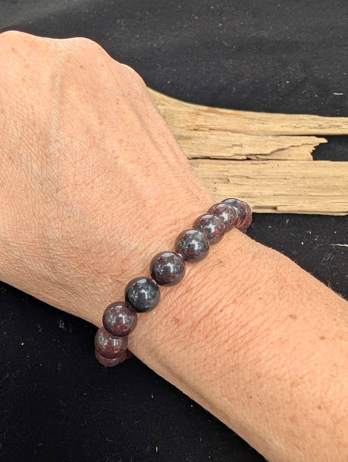 8mm polished Chicken Blood Jasper beaded stretch bracelet worn on a wrist for size scale.