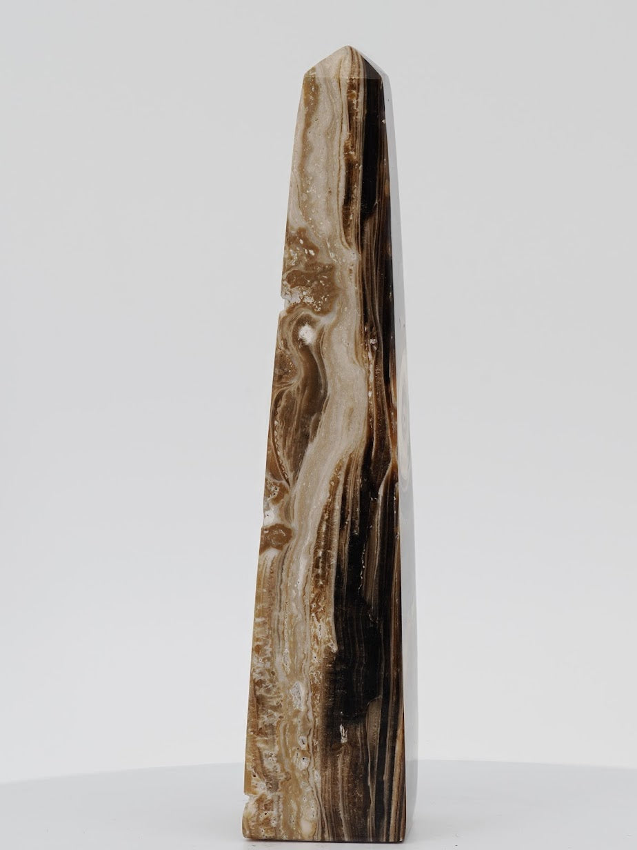 Side view of a Chocolate Banded Onyx tower showing natural espresso and cream mineral swirls and polished luster.