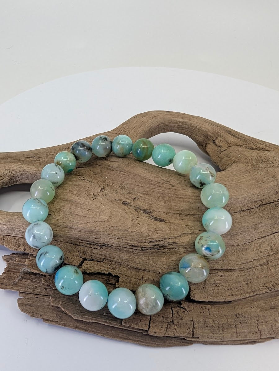 8mm Chrysocolla in Quartz bead bracelet from Peru showing Robin's egg blue plumes on natural wood.
