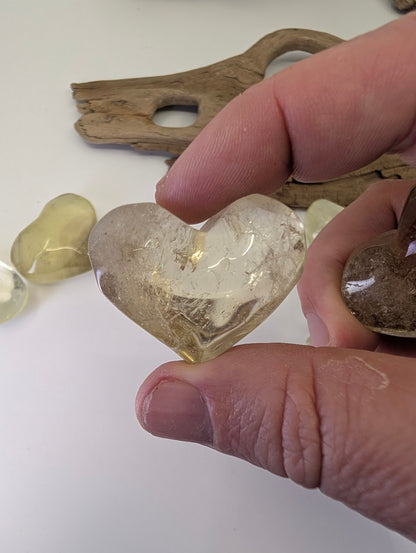 Backlit view of a Natural Citrine Heart (35g) showing high transparency and natural internal fractures.