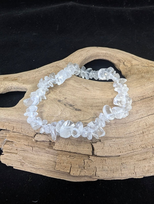 Natural clear calcite chip bracelet with high-transparency mineral fragments displayed on driftwood.