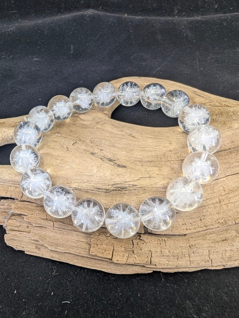 Full view of a 12mm Clear Quartz bracelet with white Sea Urchin inclusions on a driftwood base.