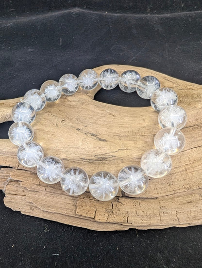 Full view of a 12mm Clear Quartz bracelet with white Sea Urchin inclusions on a driftwood base.