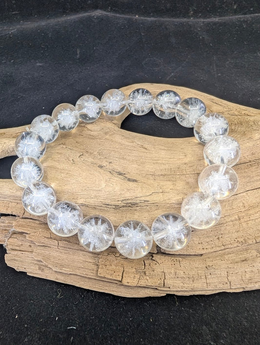 Full view of a 12mm Clear Quartz bracelet with white Sea Urchin inclusions on a driftwood base.