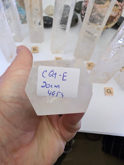The flat base of a 20cm Clear Quartz tower labeled CQT-E, 495g.