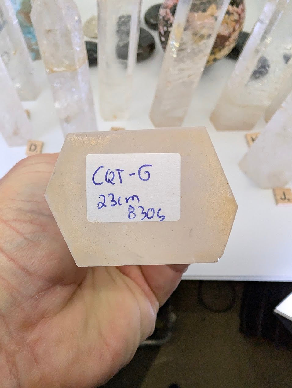 The unpolished flat base of a 23cm Clear Quartz tower labeled CQT-G, 830g.