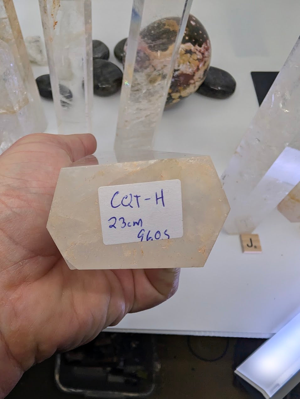 The hexagonal flat base of a 23cm Clear Quartz obelisk labeled CQT-H, 960g.