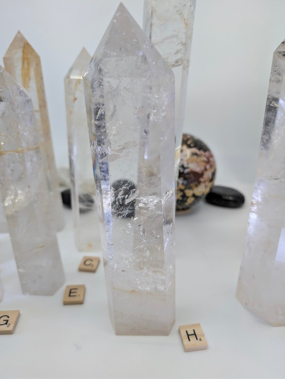 Polished 23cm Clear Quartz tower (CQT-H) standing up, showcasing dense internal structures and subtle golden inclusions.