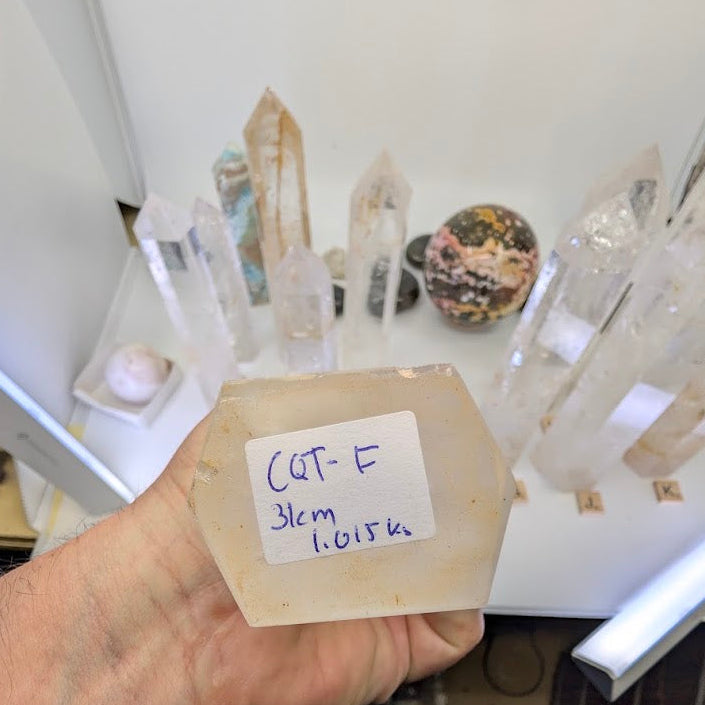 The large hexagonal base of a 31cm Clear Quartz tower labeled CQT-F, 1015g.