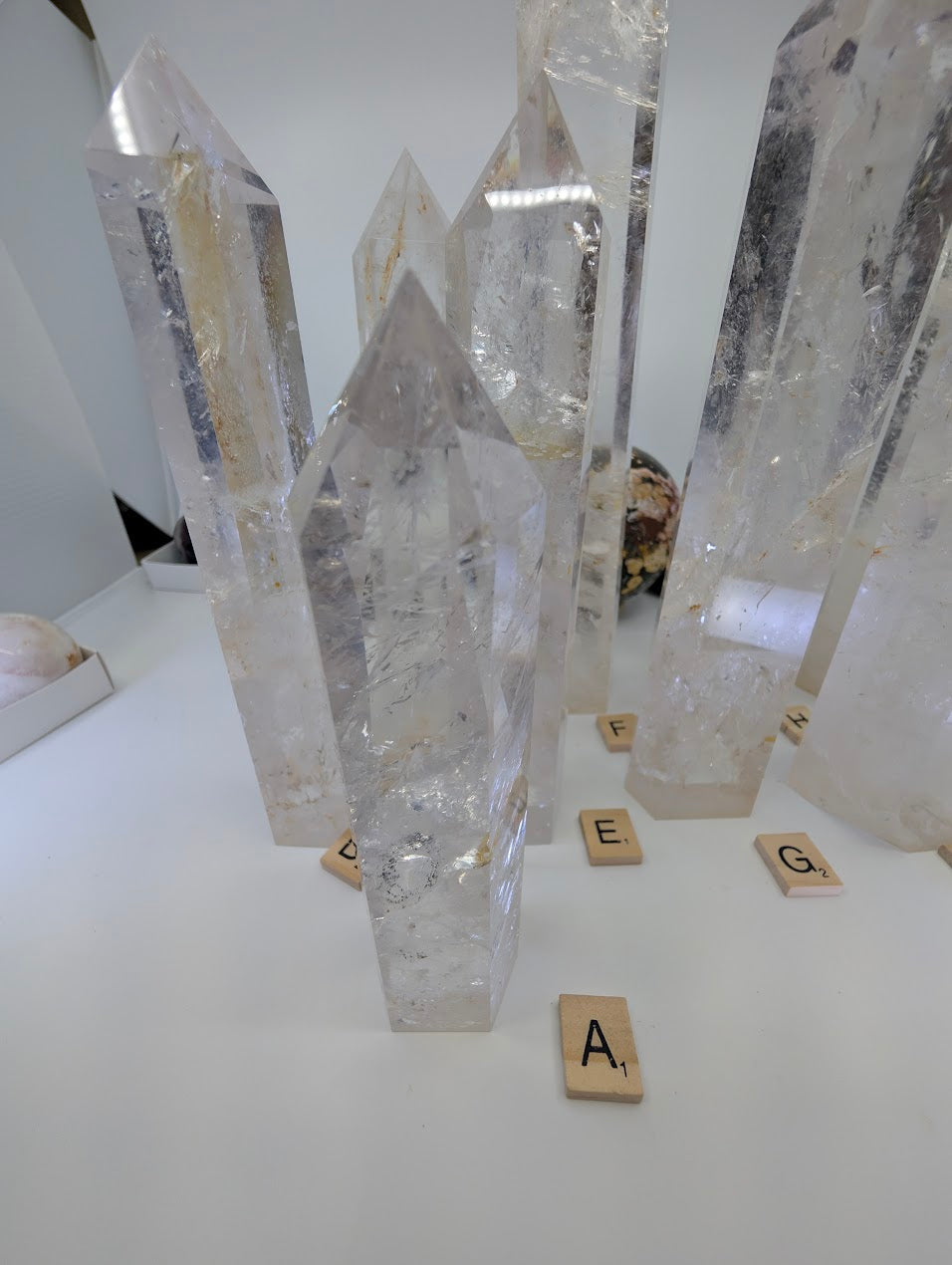 Close-up view of a collection of polished Clear Quartz obelisks showing natural internal fracture planes and light refraction.