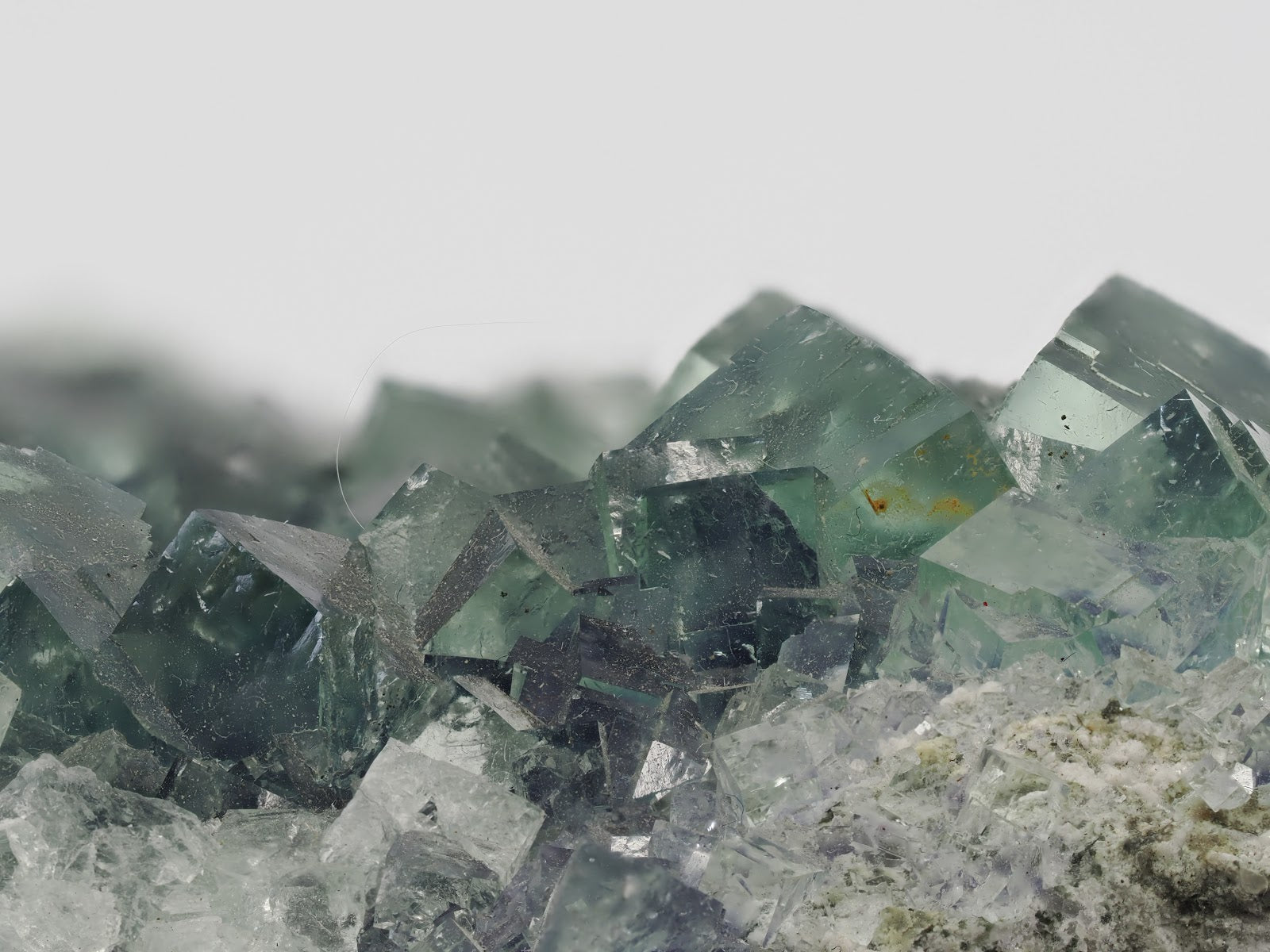 Extreme close-up focusing on the geometric edges and faint violet zoning of the crystals.