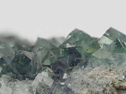 Extreme close-up focusing on the geometric edges and faint violet zoning of the crystals.