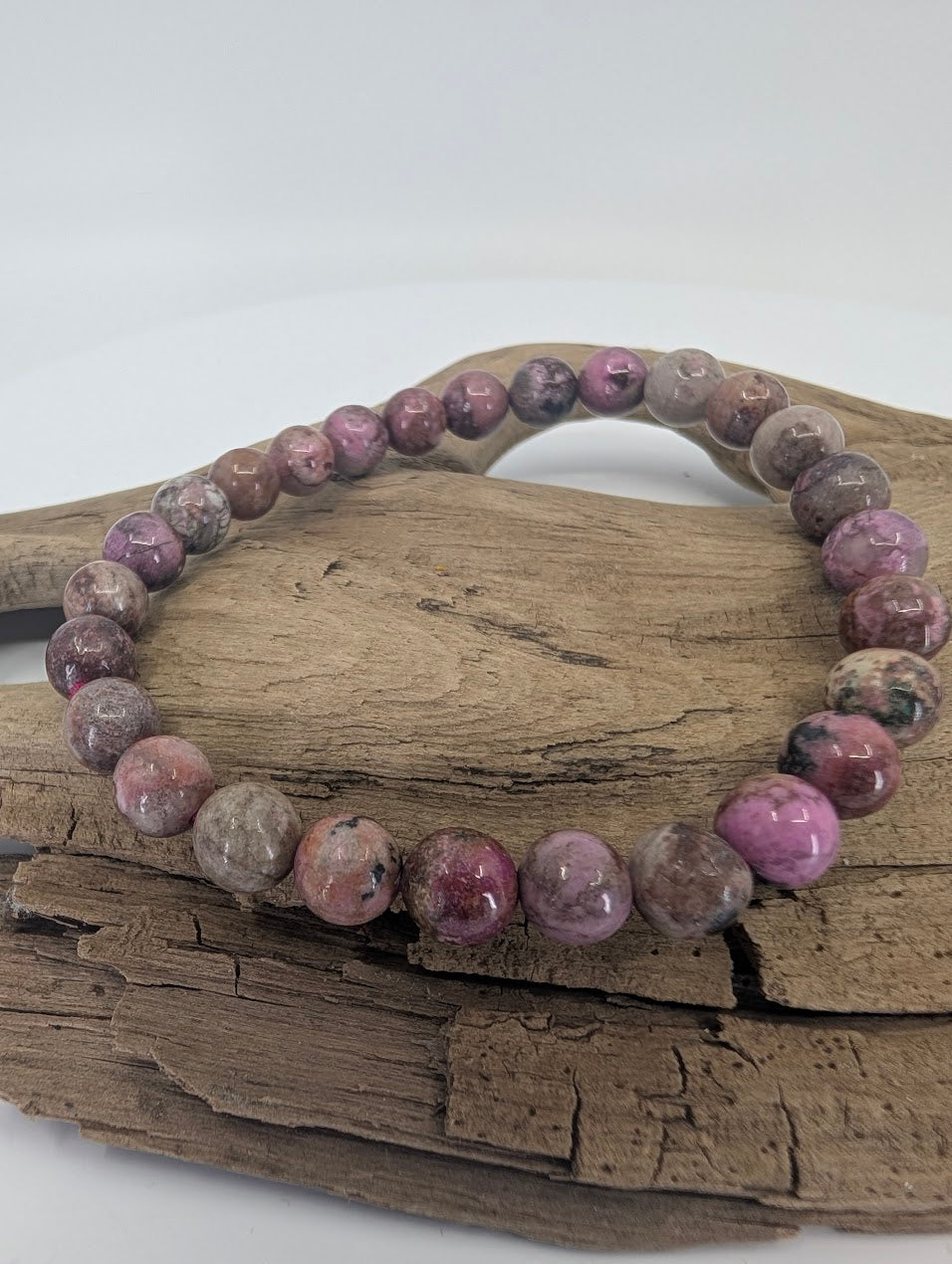 Cobaltoan Calcite bracelet with 7mm beads displayed on driftwood