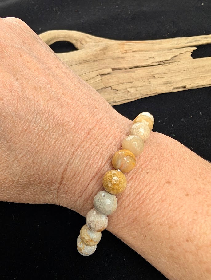 8mm faceted Coral Jade beaded stretch bracelet worn on a wrist for size scale.