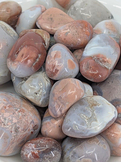 Close-up of Cotton Candy Agate tumbled stones showing pastel banding and polish