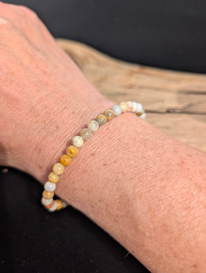 Natural sunlight on a 4mm multi-coloured Crazy Lace Agate stretch bracelet worn on a wrist.
