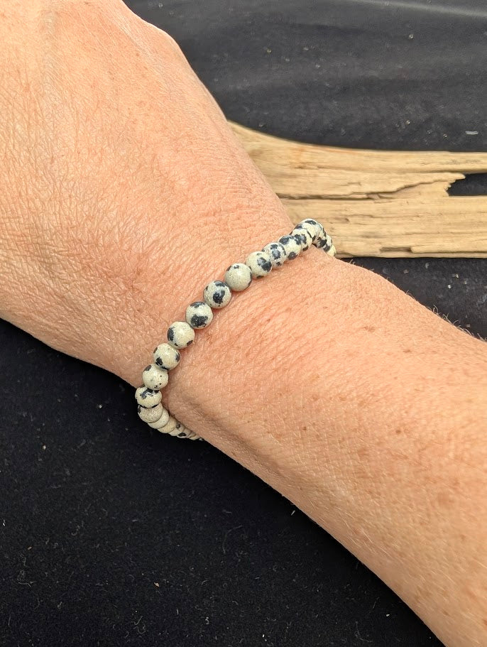 4mm polished Dalmatian Jasper beaded stretch bracelet worn on a wrist for delicate size scale.