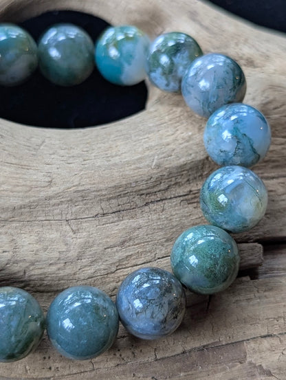 Close-up macro view of 13mm Dark Moss Agate beads showing bold, expansive mossy inclusions and exceptional translucency.
