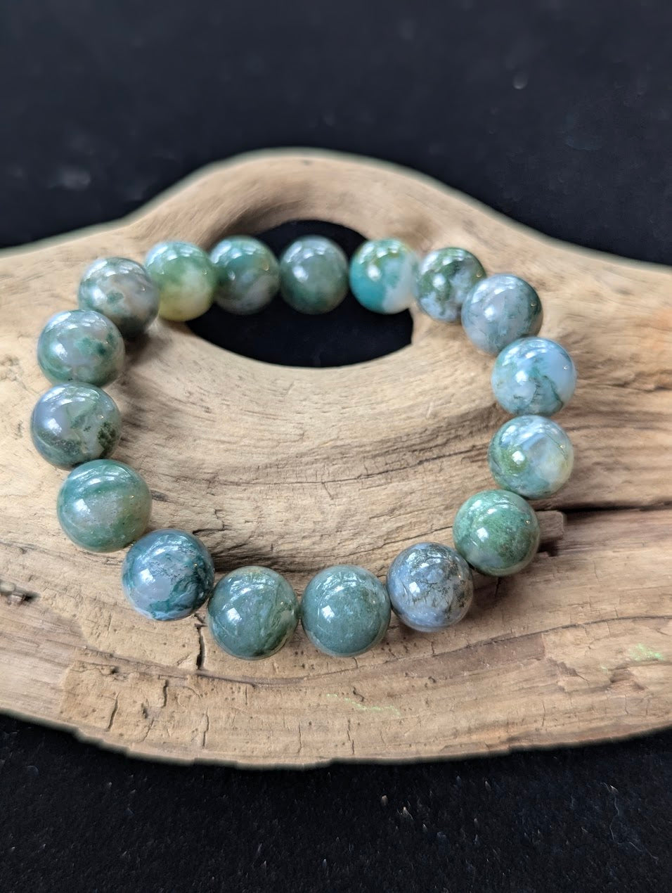 13mm High-Quality Dark Moss Agate heavy statement bracelet resting on organic driftwood.
