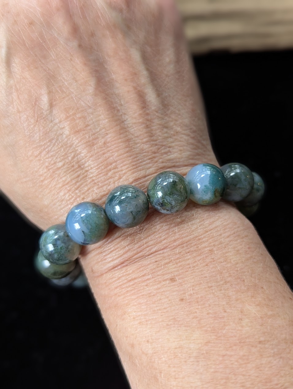 Bold 13mm Dark Moss Agate gemstone bracelet styled on a wrist for a prominent, grounding look.