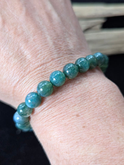 8mm Dark Moss Agate gemstone bracelet worn on a wrist, demonstrating scale and natural green aesthetic.