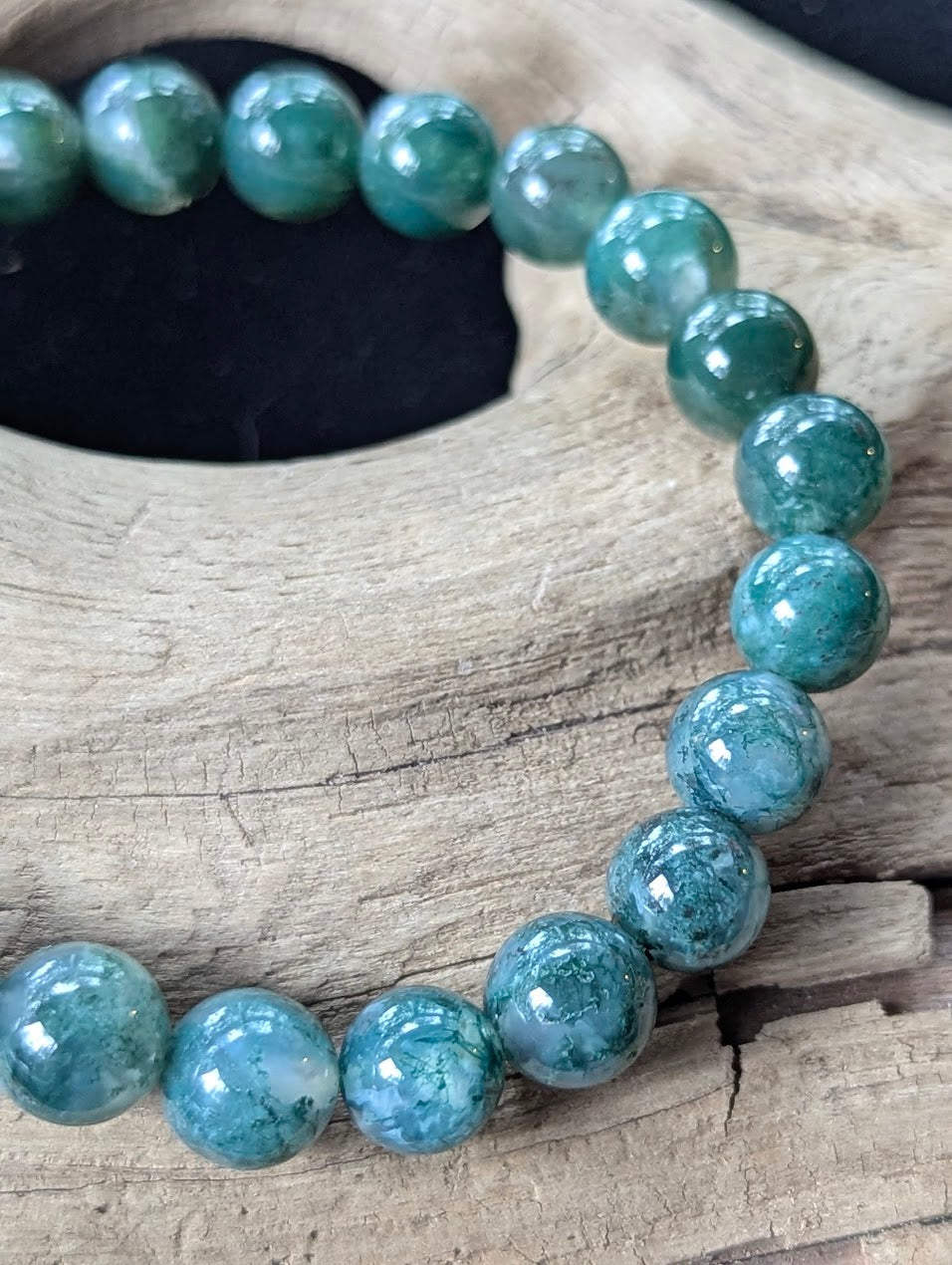 Detailed macro view of 9mm Dark Moss Agate beads showcasing vibrant green dendritic inclusions and glassy lustre.