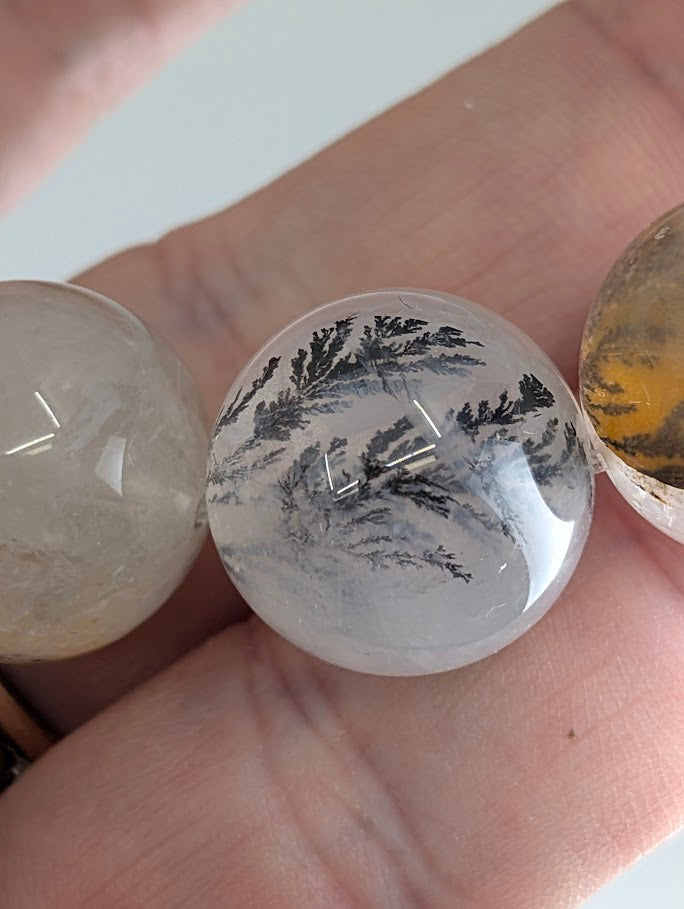 Macro photo of dendritic quartz beads with detailed manganese oxide inclusions.