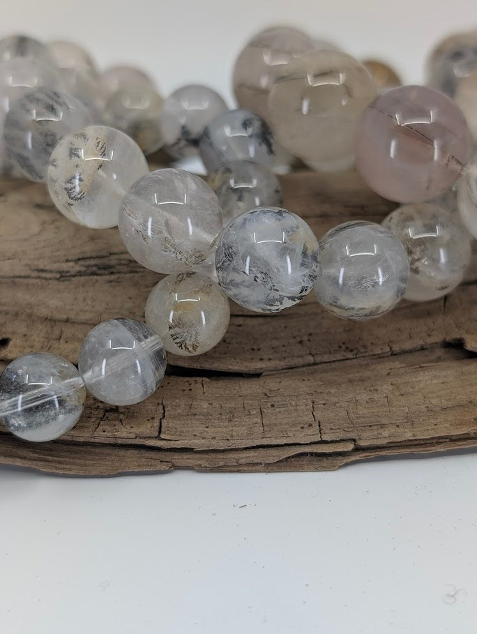 Macro photo of dendritic quartz beads with detailed manganese oxide inclusions.