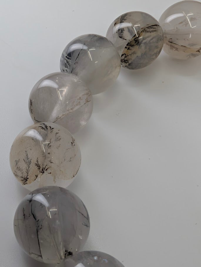 Close-up of 14mm dendritic quartz bracelet photographed from top view showing full bead patterning.