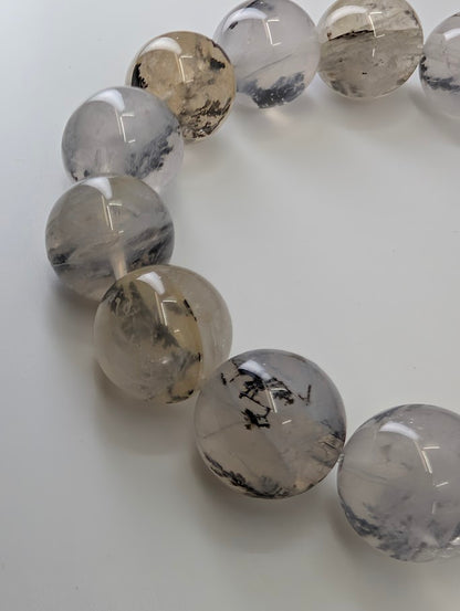 Close-up of 15mm dendritic quartz bracelet highlighting high-clarity beads with bold dendrite structures.