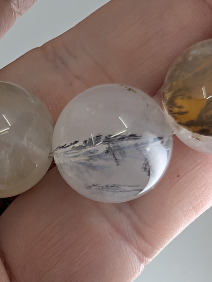 16mm dendritic quartz bracelet showing natural manganese oxide inclusions and clear quartz beads.