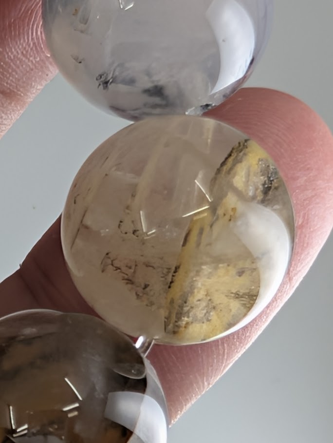 16mm dendritic quartz bracelet showing natural manganese oxide inclusions and clear quartz beads.