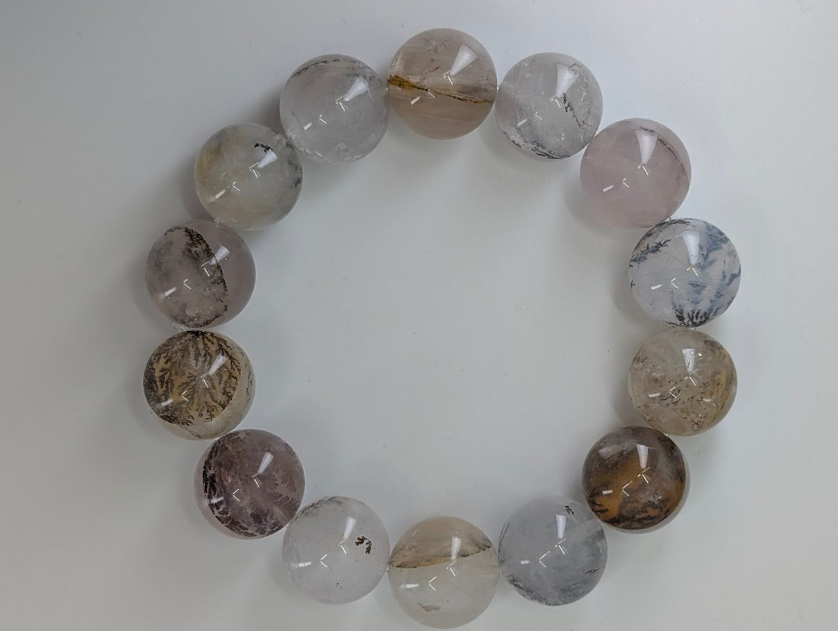16mm dendritic quartz bracelet showing natural manganese oxide inclusions and clear quartz beads
