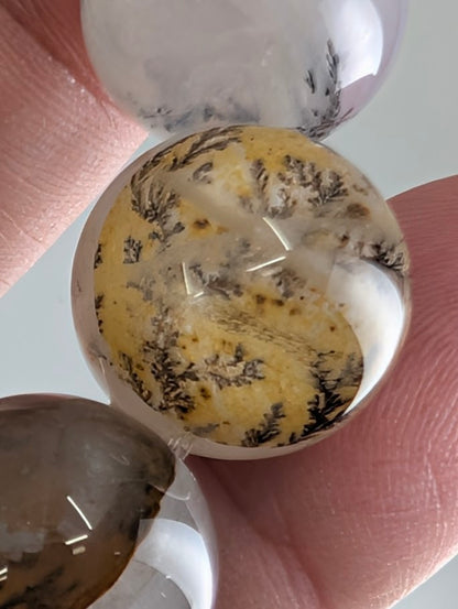 16mm dendritic quartz bracelet showing natural manganese oxide inclusions and clear quartz beads.