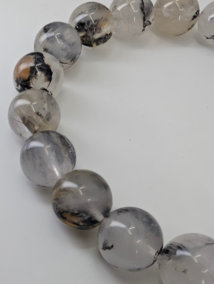 Close-up of 8mm dendritic quartz bracelet photographed from top view showing full bead patterning.