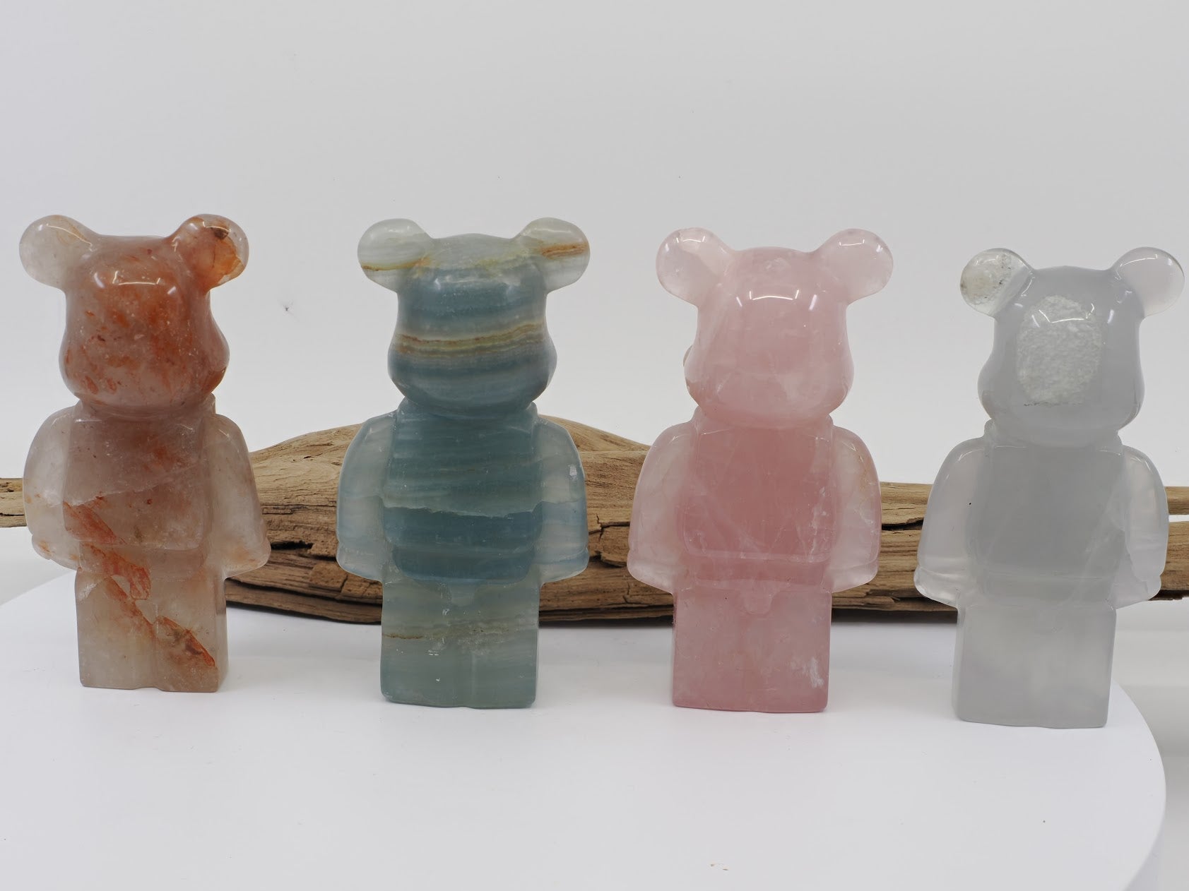 Rear view of the four crystal bear carvings showing the continuous natural banding and texture of the minerals.